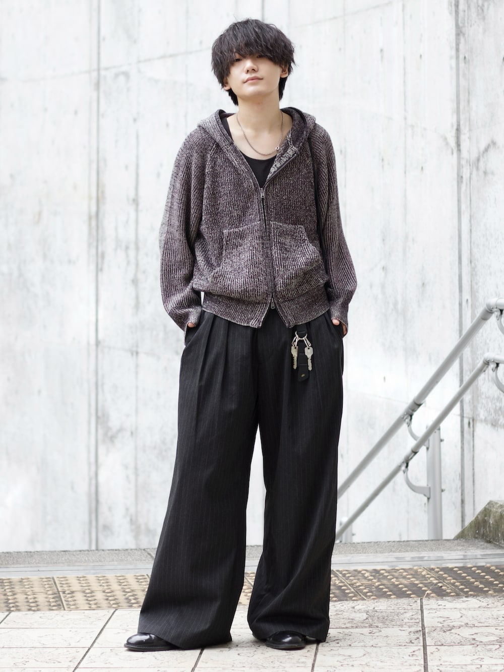 グレー系のニット/セーター、ブラック系のタンクトップ、グレー系のスラックスを着用したメンズの秋コーディネートの2枚目の写真