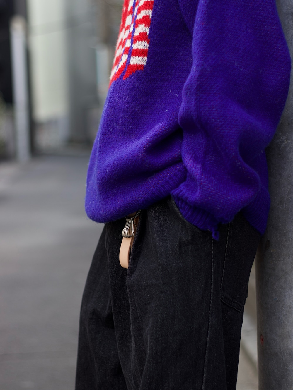 ブルー系のニット/セーター、ブラック系のデニムパンツ、ブラック系のブーツを着用したメンズの春コーディネートの4枚目の写真