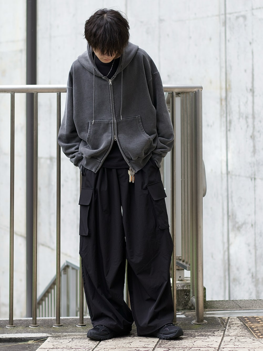 グレー系のパーカー、ブラック系のタンクトップ、ブラック系のカーゴパンツを着用したメンズの秋コーディネートの2枚目の写真