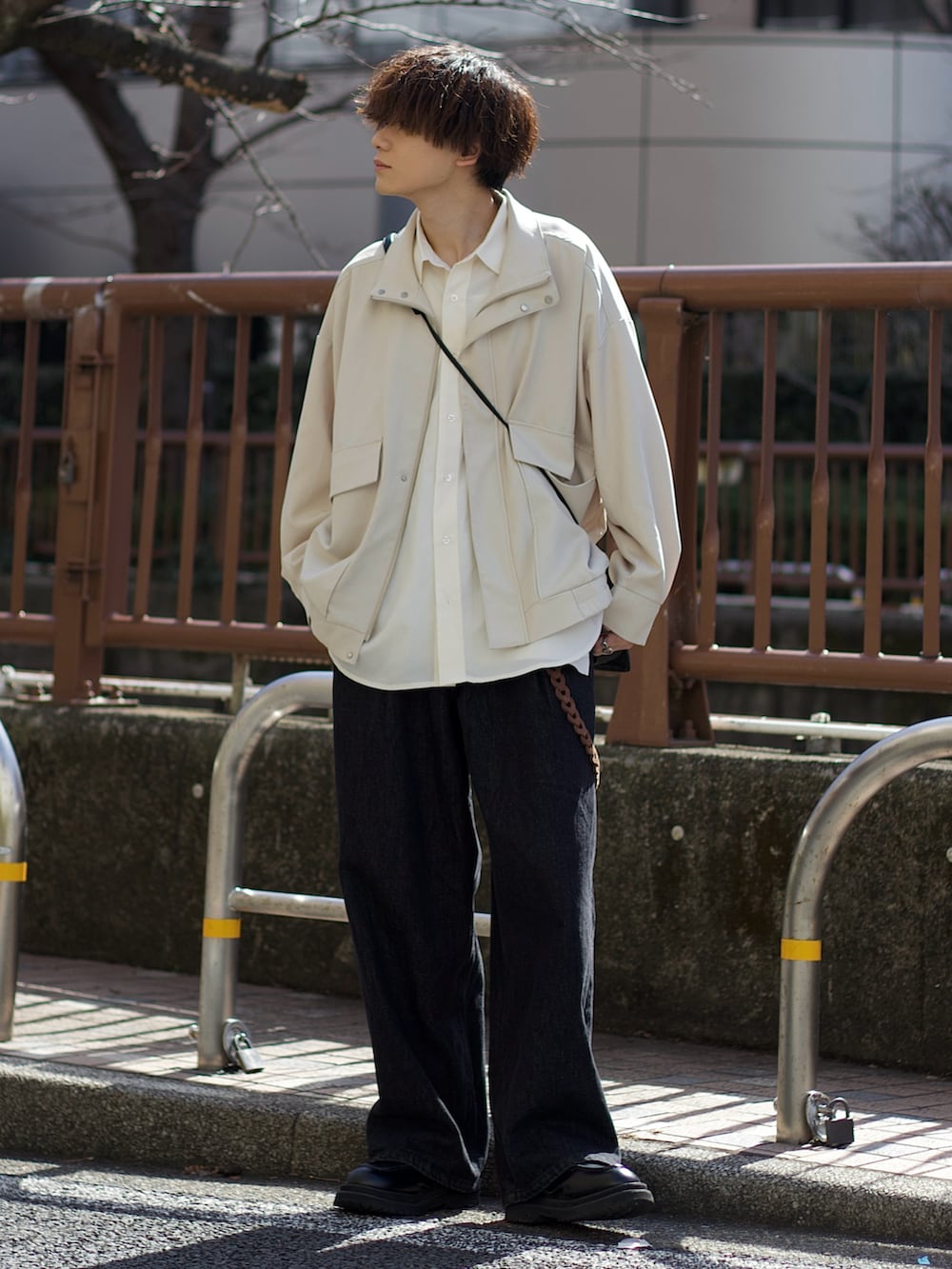 ホワイト系のブルゾン、ホワイト系のタンクトップ、ブラック系のデニムパンツを着用したメンズの冬コーディネートの2枚目の写真