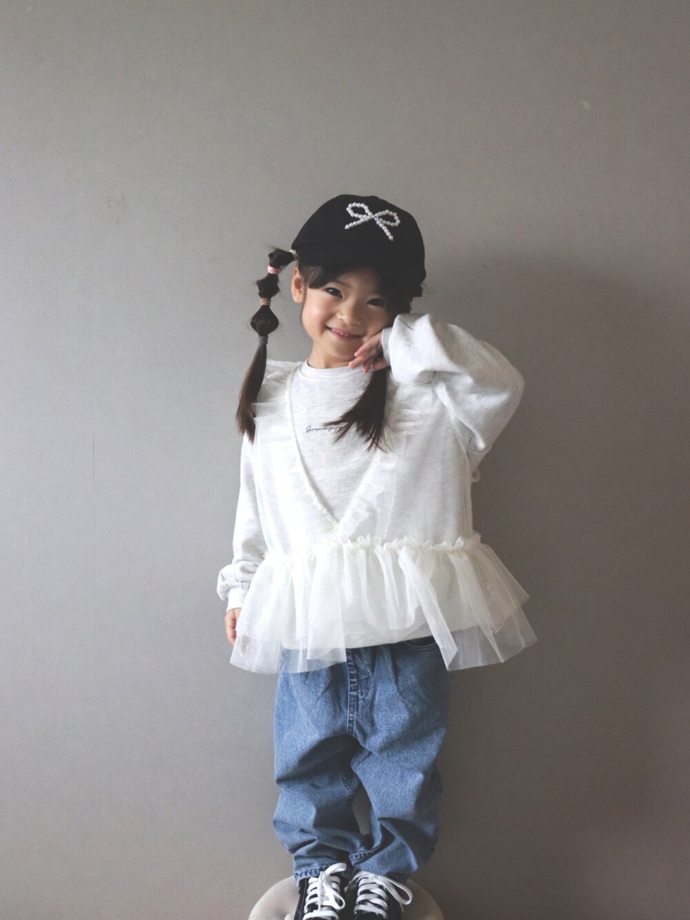 ホワイト系のスウェット、ブルー系のデニムパンツ、ブラック系のキャップを着用したキッズの冬コーディネートの4枚目の写真