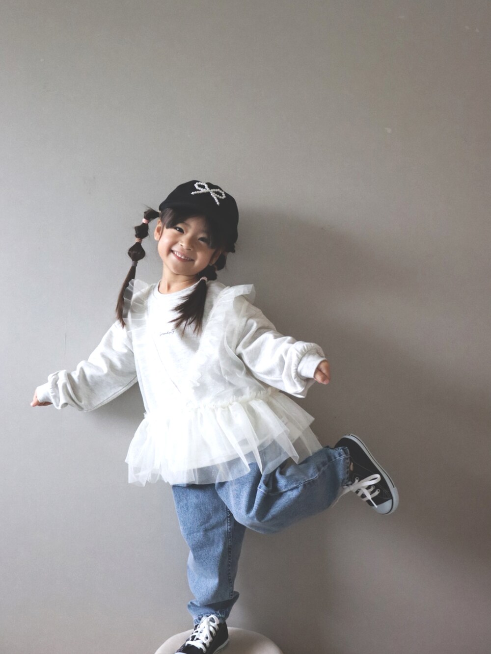 ホワイト系のスウェット、ブルー系のデニムパンツ、ブラック系のキャップを着用したキッズの冬コーディネートの3枚目の写真