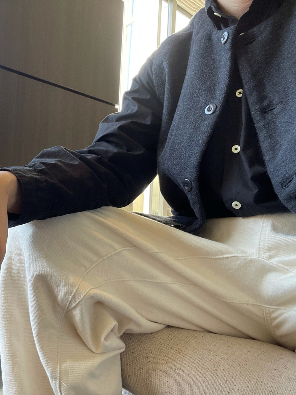 ホワイト系のパンツ、ブラック系のシューズ、ブラック系のベストを着用したメンズの秋コーディネートの2枚目の写真