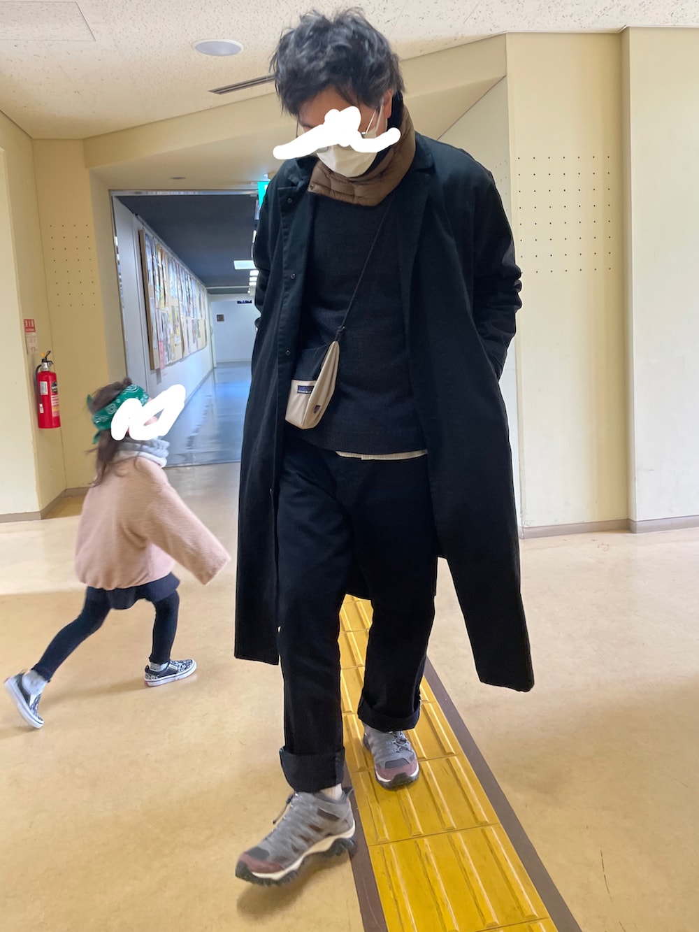 ブラック系のステンカラーコート、グレー系のシューズ、ブラック系のデニムパンツを着用したメンズの冬コーディネートの2枚目の写真