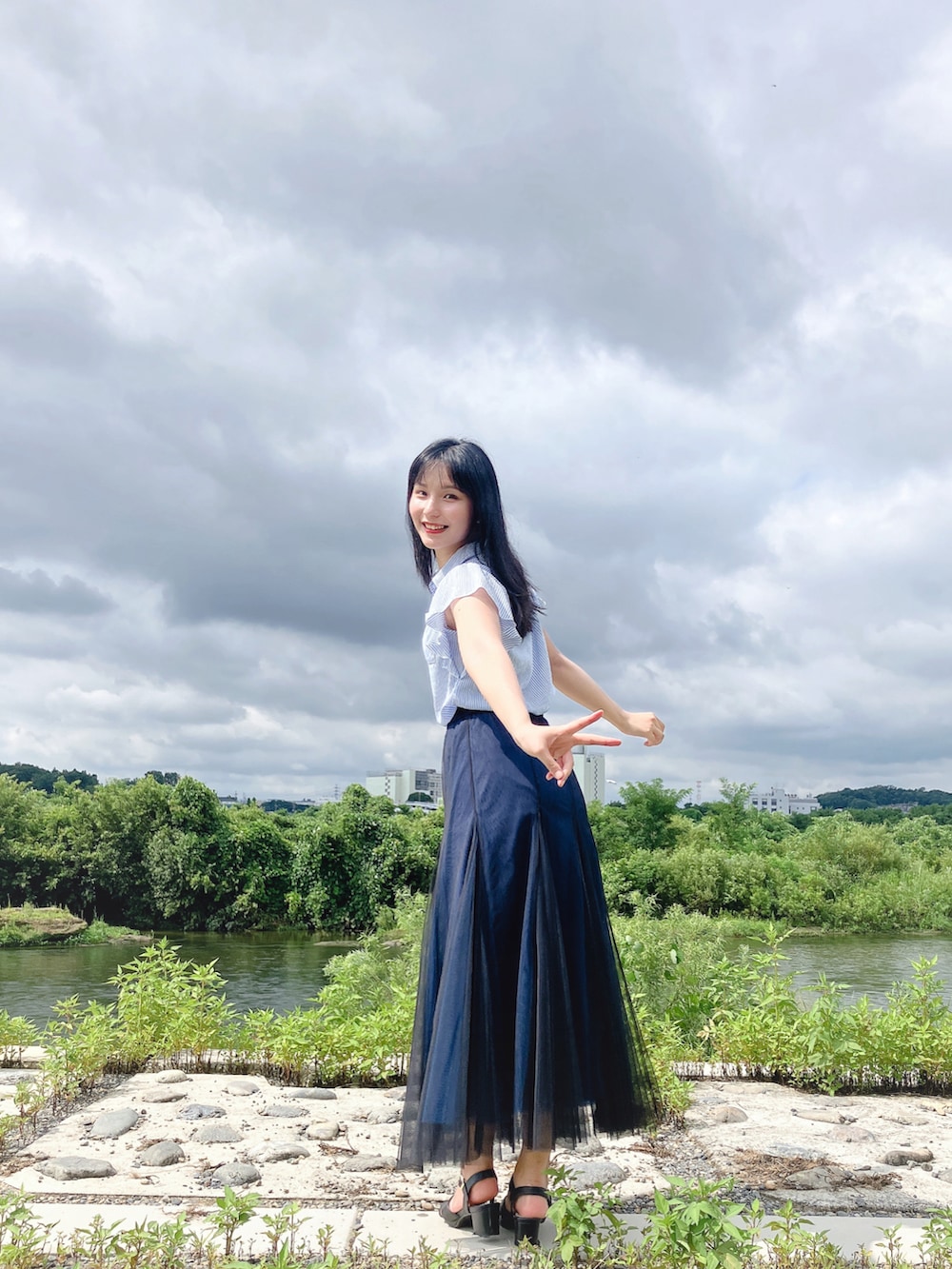 ブルー系のスカート、ブラック系のサンダル、ブルー系のシャツ/ブラウスを着用したレディースの夏コーディネートの2枚目の写真