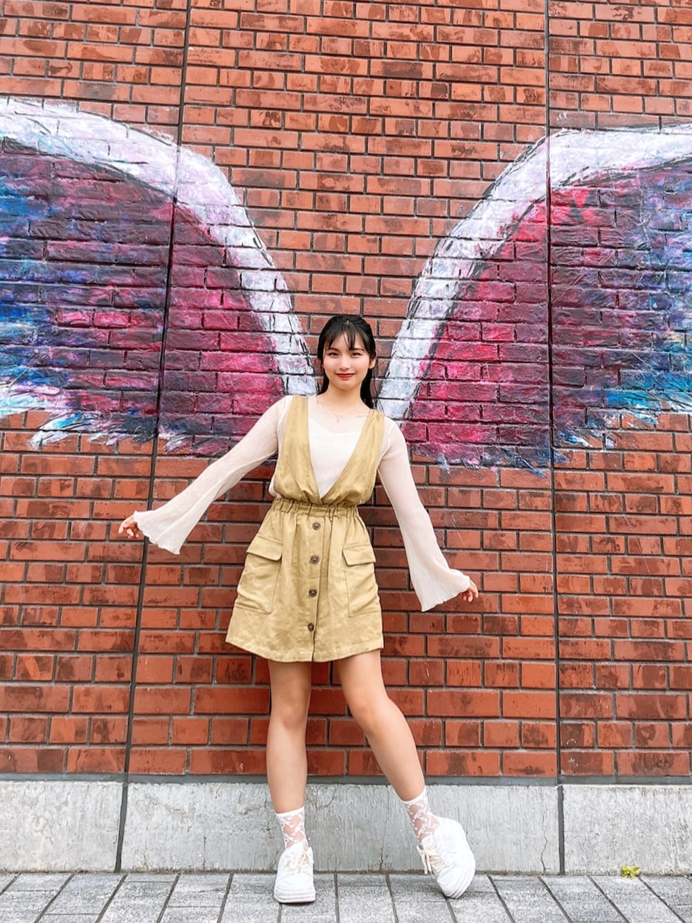 ベージュ系のバッグ、ベージュ系のシャツ/ブラウス、グリーン系のジャンパースカートを着用したレディースの夏コーディネートの2枚目の写真