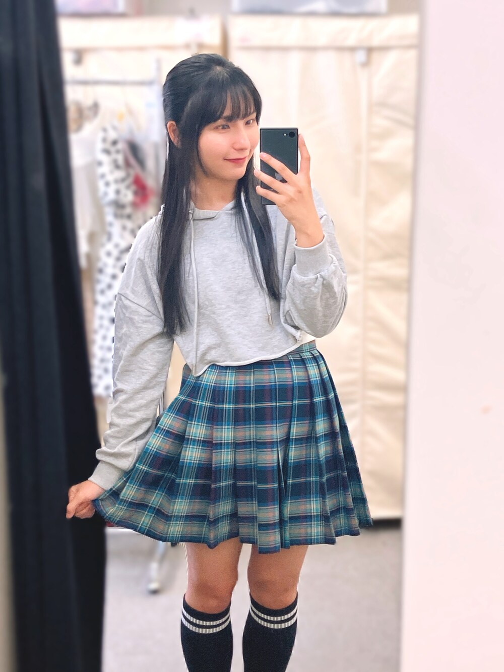 グレー系のパーカー、ブルー系のスカート、レッド系のサンダルを着用したレディースの夏コーディネートの2枚目の写真