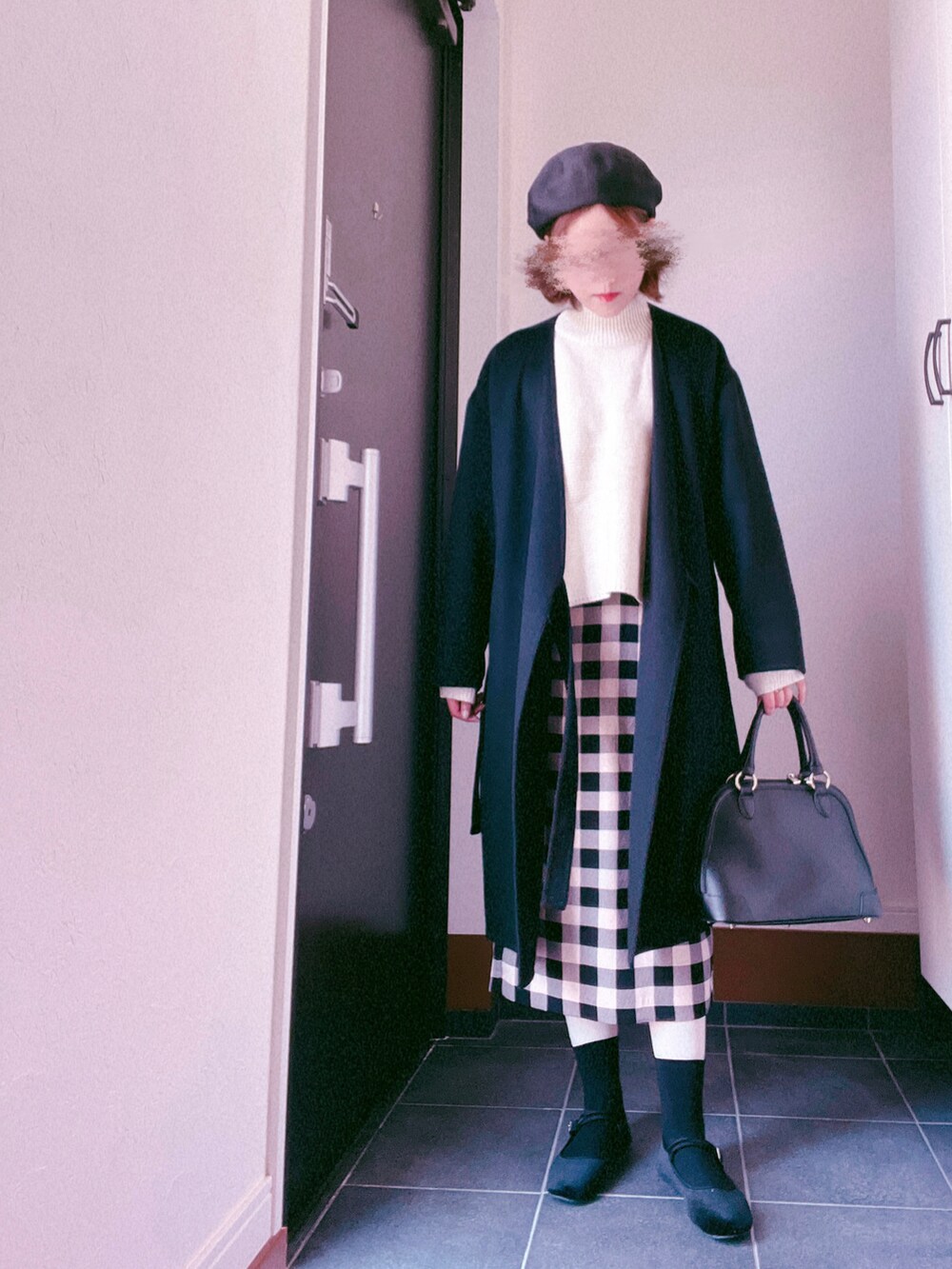 ホワイト系のニット/セーター、その他のスカート、ブラック系のハンドバッグを着用したレディースの春コーディネートの2枚目の写真