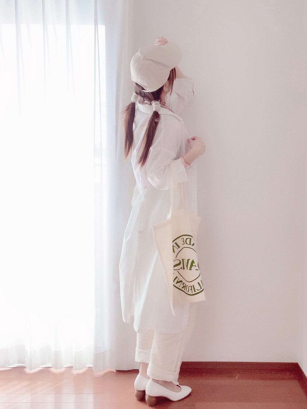 レッド系のタンクトップ、ベージュ系のキャップを着用したレディースの春コーディネートの2枚目の写真