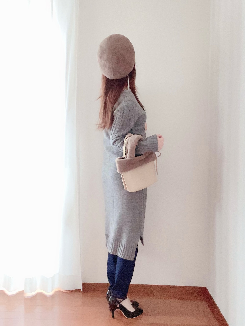 ブラウン系のバッグ、ブラック系のパンプス、グレー系のワンピースを着用したレディースの春コーディネートの3枚目の写真