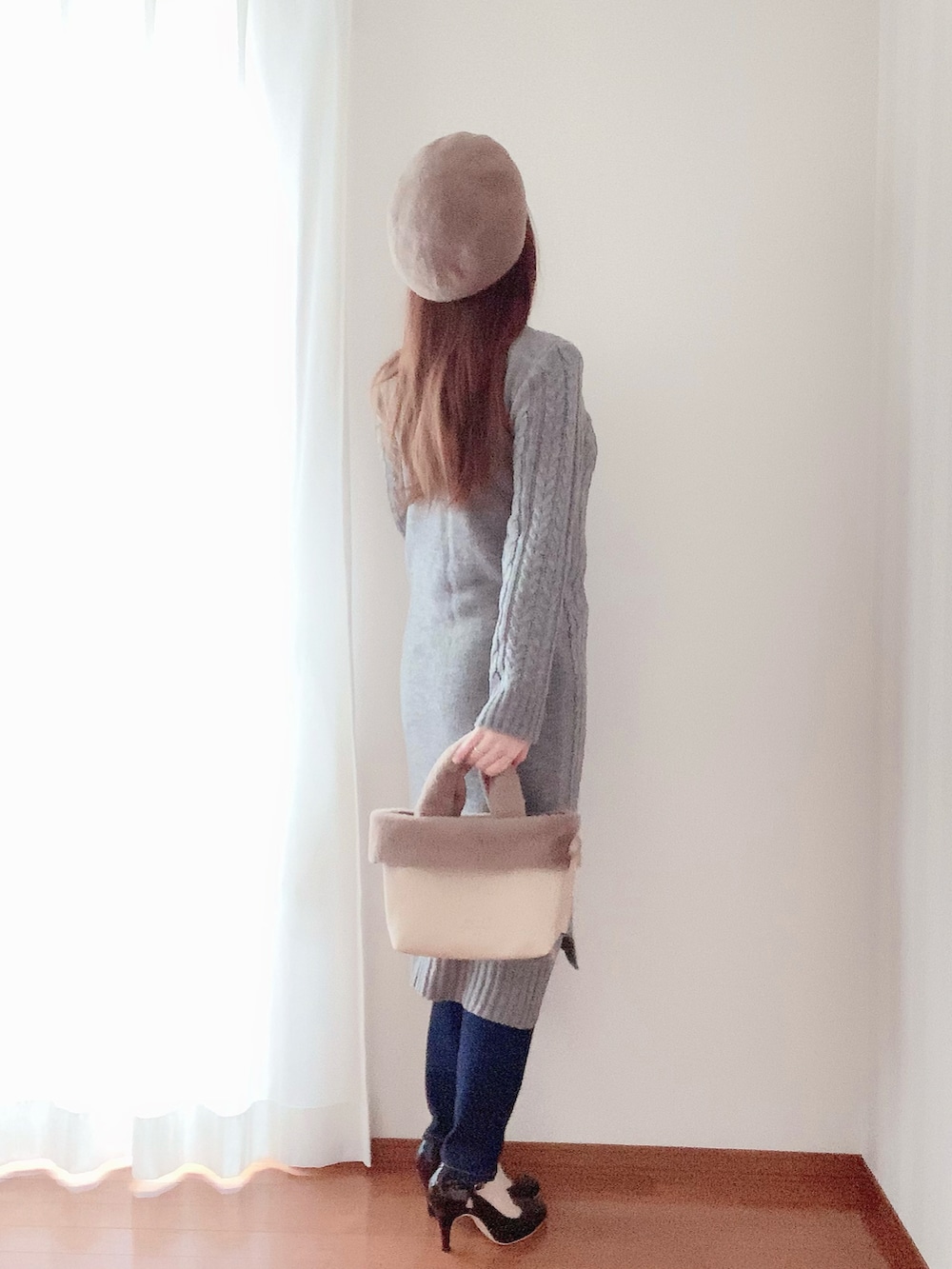 ブラウン系のバッグ、ブラック系のパンプス、グレー系のワンピースを着用したレディースの春コーディネートの2枚目の写真