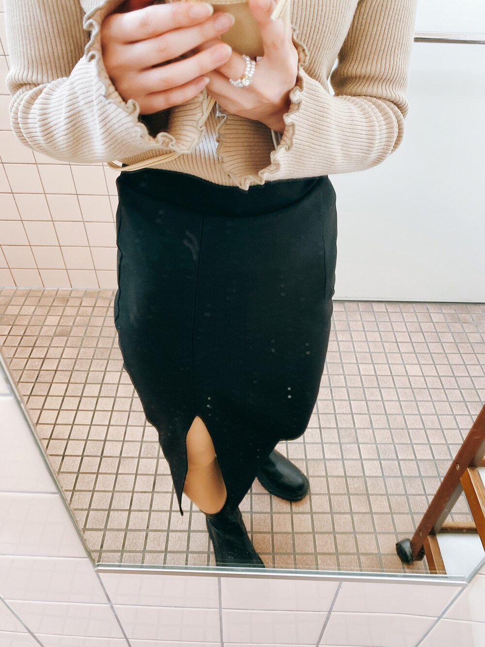 ホワイト系のダウンジャケット/コート、ブラック系のブーツ、ブラック系のショルダーバッグを着用したレディースの春コーディネートの4枚目の写真