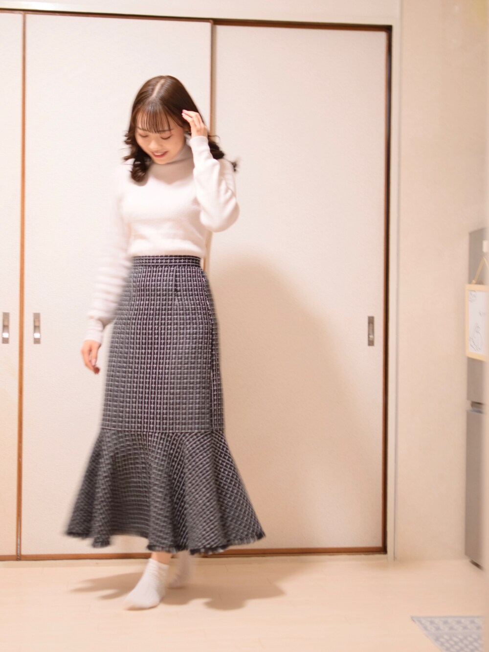 ブルー系のジャケット/アウター、ホワイト系のニット/セーター、ブラック系のスカートを着用したレディースの冬コーディネートの2枚目の写真