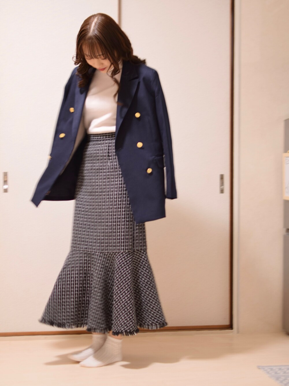 ブルー系のジャケット/アウター、ホワイト系のニット/セーター、ブラック系のスカートを着用したレディースの冬コーディネートの3枚目の写真