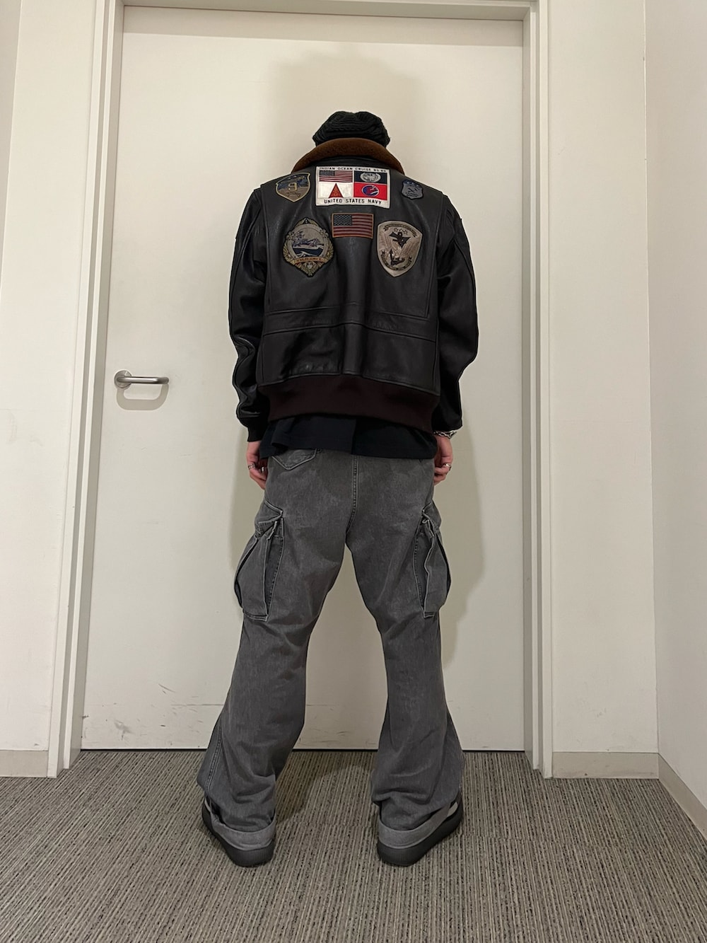 ブラウン系のミリタリージャケット、ブラック系のカーゴパンツを着用したメンズの冬コーディネートの2枚目の写真