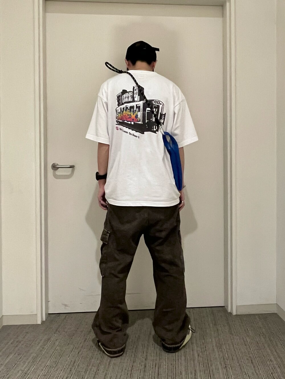 ホワイト系のTシャツ/カットソー、ブルー系のバッグを着用したメンズの春コーディネートの2枚目の写真