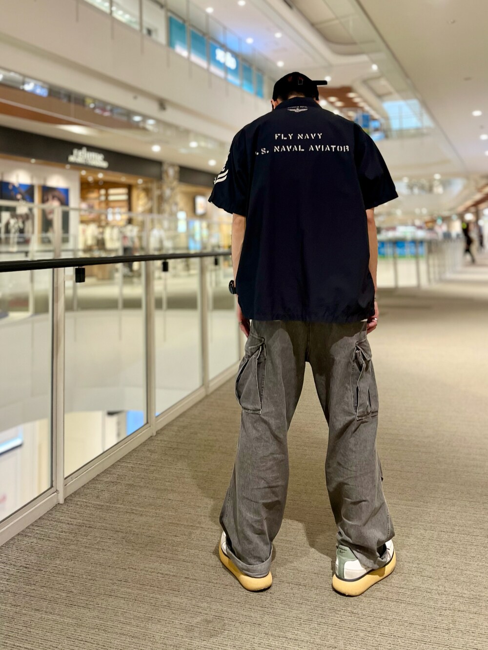 ブルー系のシャツ/ブラウス、ブラック系のカーゴパンツ、ブラック系のキャップを着用したメンズの春コーディネートの2枚目の写真