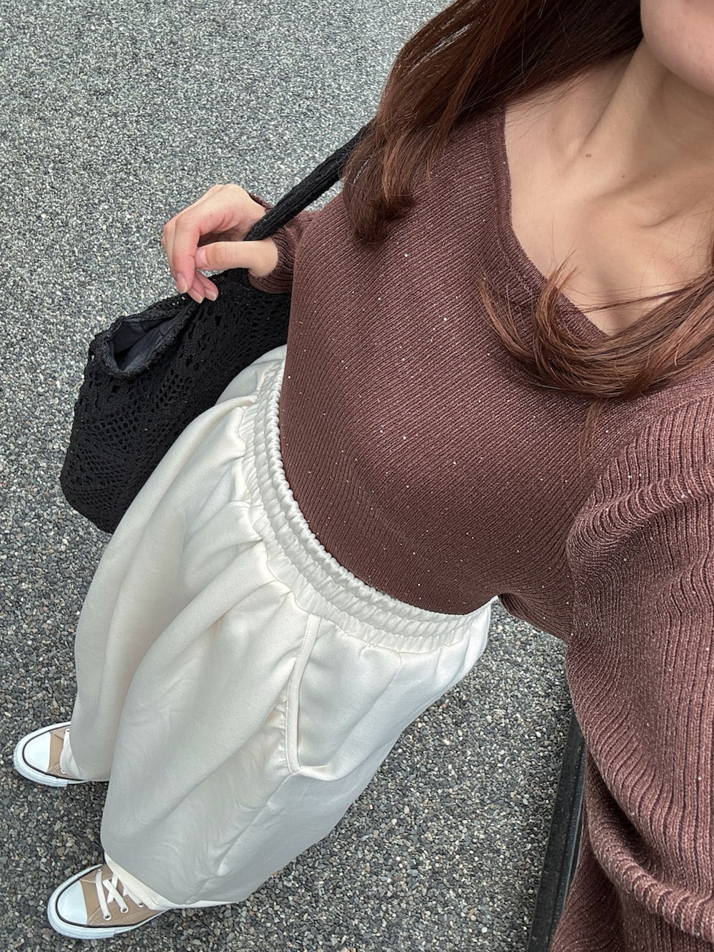 ブラウン系のニット/セーター、ベージュ系のスウェットパンツ、ベージュ系のスニーカーを着用したレディースの秋コーディネートの2枚目の写真