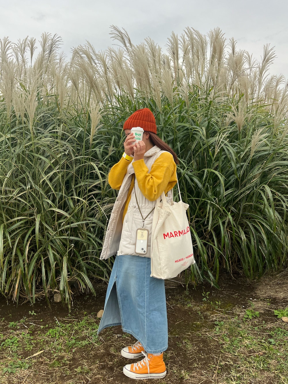 ホワイト系のダウンベスト、イエロー系のニット/セーター、ホワイト系のトートバッグを着用したレディースの秋コーディネートの2枚目の写真