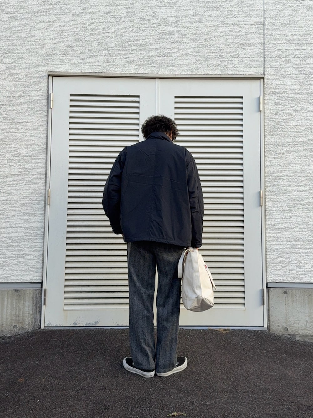 ブラック系のモッズコート、ブルー系のニット/セーター、グレー系のその他パンツを着用したメンズの冬コーディネートの3枚目の写真