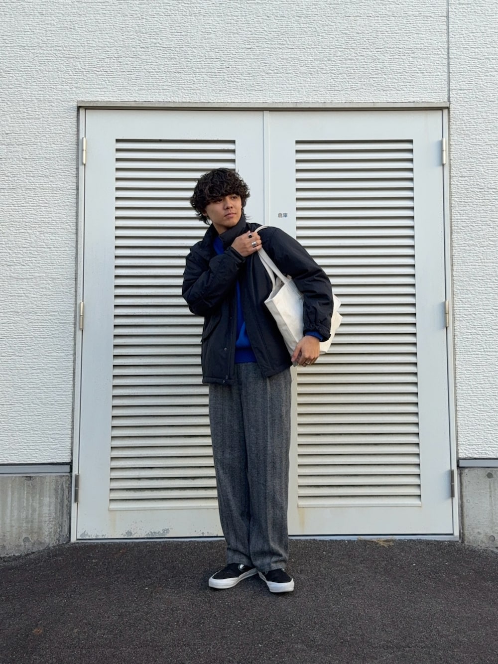 ブラック系のモッズコート、ブルー系のニット/セーター、グレー系のその他パンツを着用したメンズの冬コーディネートの2枚目の写真