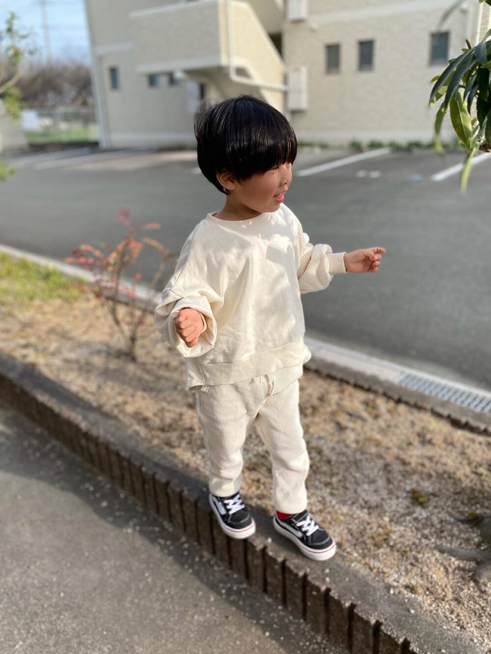 ホワイト系のスウェット、ホワイト系のスウェットパンツ、ブラック系のスニーカーを着用したキッズの春コーディネートの2枚目の写真