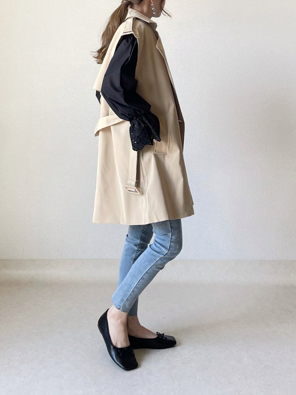 ベージュ系のベスト、ブラック系のTシャツ/カットソー、ブルー系のデニムパンツを着用したレディースの春コーディネートの2枚目の写真