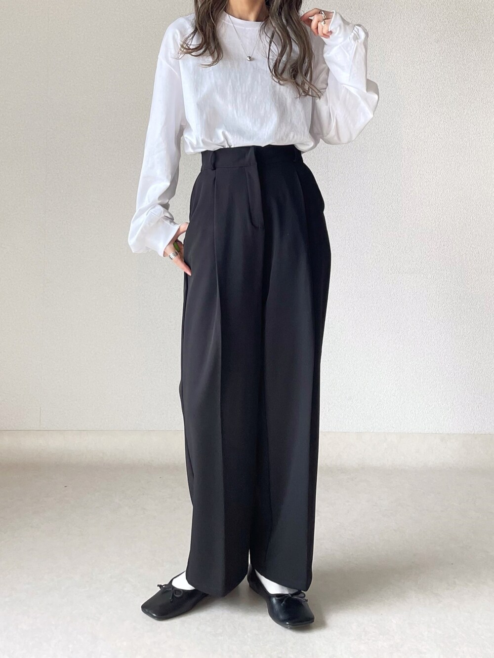 ホワイト系のTシャツ/カットソー、レッド系のカーディガン/ボレロ、ブラック系のスラックスを着用したレディースの秋コーディネートの3枚目の写真