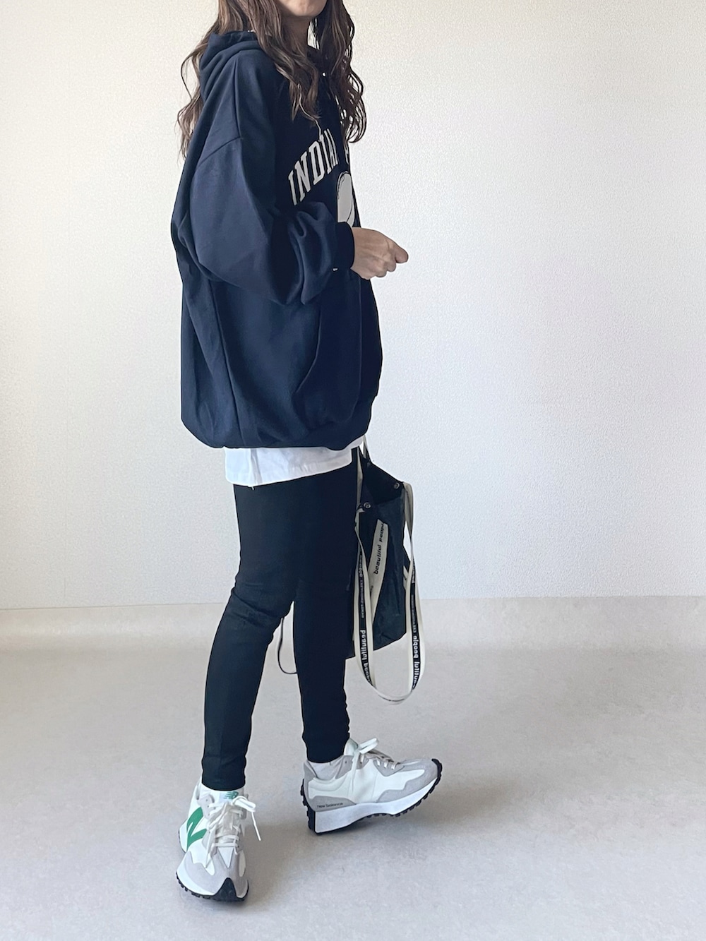 ブルー系のパーカー、ホワイト系のスカート、ブラック系のトートバッグを着用したレディースの秋コーディネートの3枚目の写真