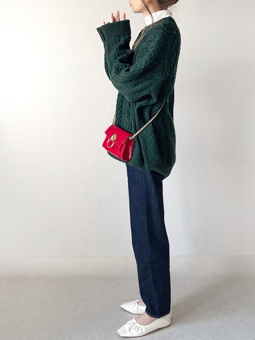 ホワイト系のニット/セーター、ブルー系のデニムパンツ、ホワイト系のパンプスを着用したレディースの冬コーディネートの3枚目の写真