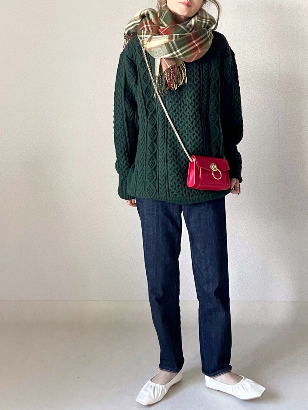 ホワイト系のニット/セーター、ブルー系のデニムパンツ、ホワイト系のパンプスを着用したレディースの冬コーディネートの2枚目の写真