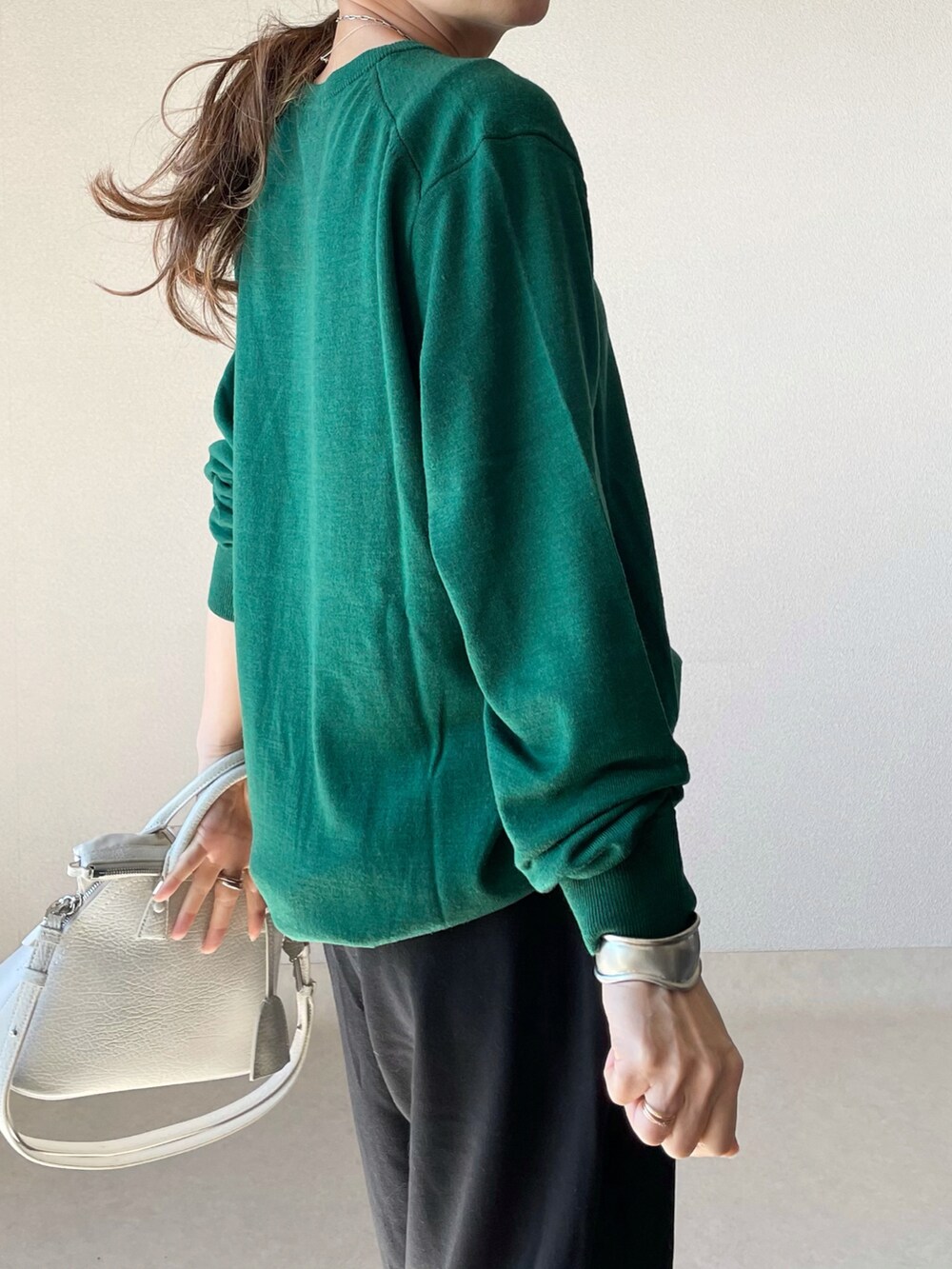 グリーン系のニット/セーター、ブラック系のスウェットパンツ、ブラック系のバレエシューズを着用したレディースの秋コーディネートの4枚目の写真