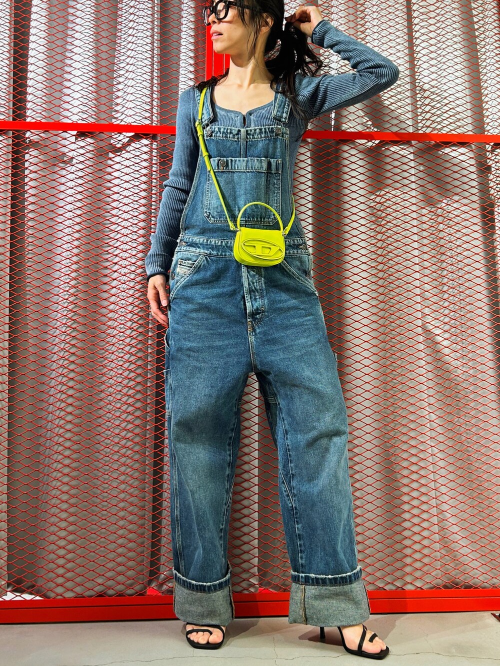 ブルー系のサロペット/オーバーオール、イエロー系のショルダーバッグ、ブルー系のニット/セーターを着用したレディースの春コーディネートの3枚目の写真