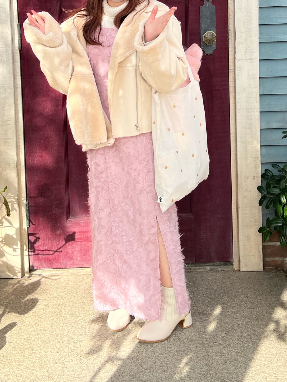 ピンク系のワンピース、ホワイト系のムートンコートを着用したレディースの冬コーディネートの3枚目の写真