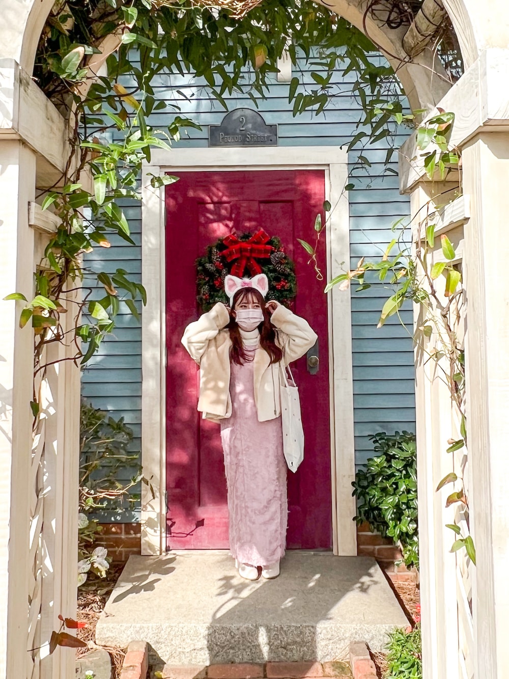 ピンク系のワンピース、ホワイト系のムートンコートを着用したレディースの冬コーディネートの2枚目の写真