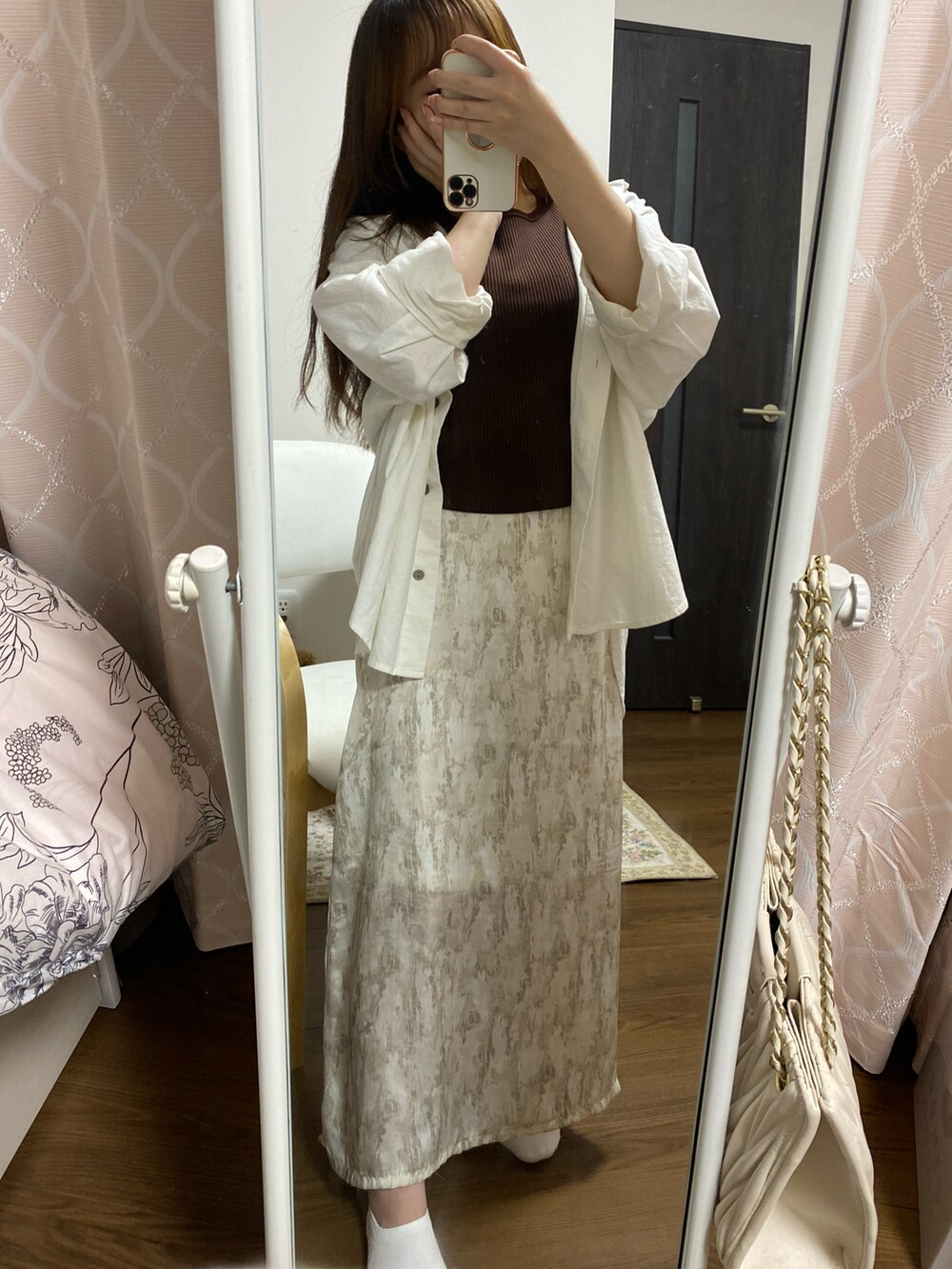 ベージュ系のスカート、ブラウン系のTシャツ/カットソー、ホワイト系のシャツ/ブラウスを着用したレディースの春コーディネートの2枚目の写真