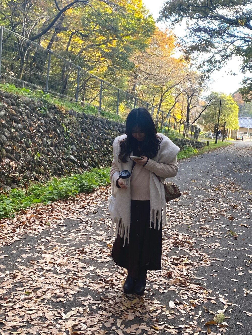 ベージュ系のショルダーバッグ、ホワイト系のニット/セーター、ブラウン系のワンピース/ドレスを着用したレディースの秋コーディネートの3枚目の写真