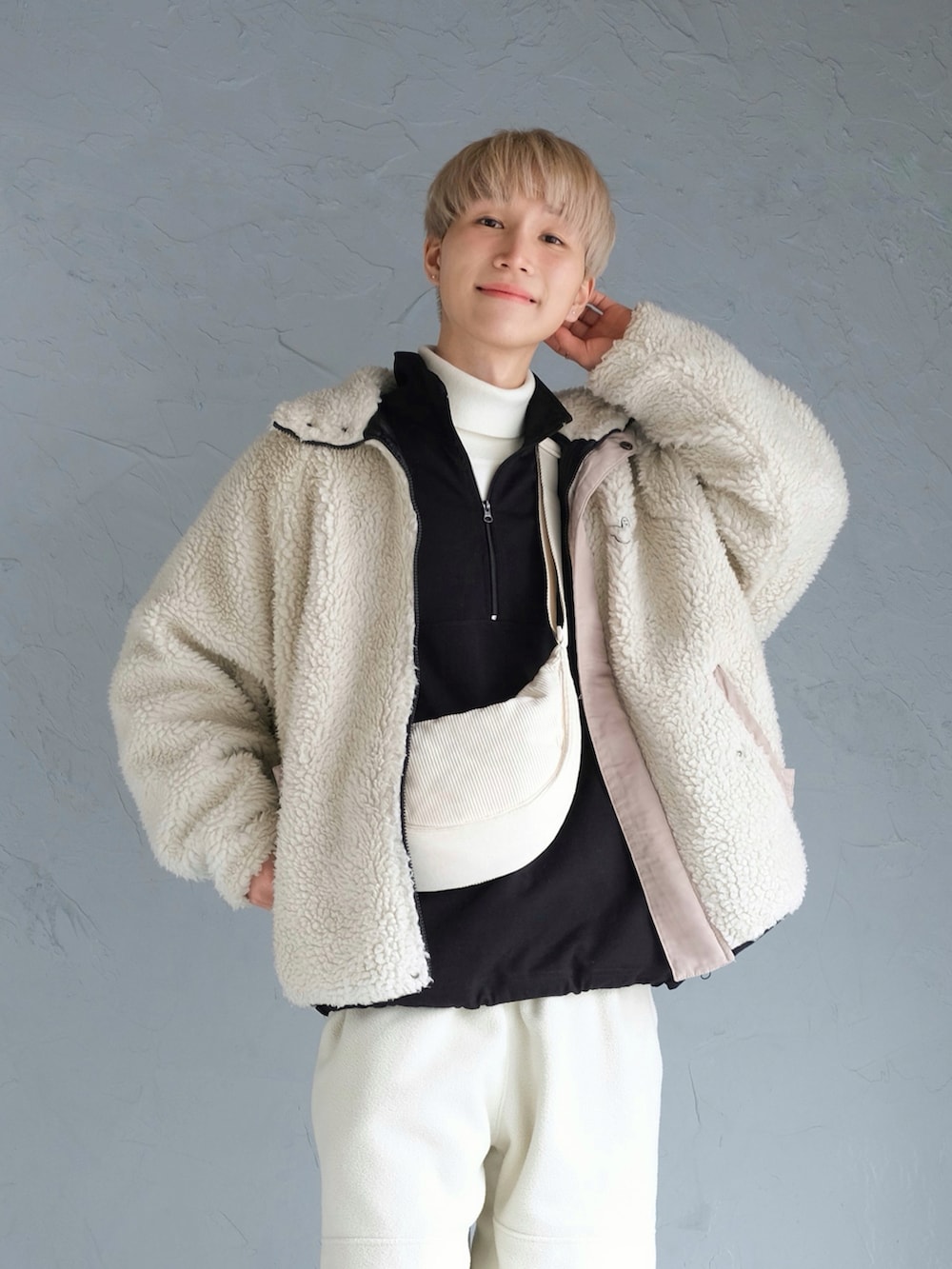 ホワイト系のスニーカー、ホワイト系のスウェットパンツ、ホワイト系のショルダーバッグを着用したメンズの冬コーディネートの2枚目の写真