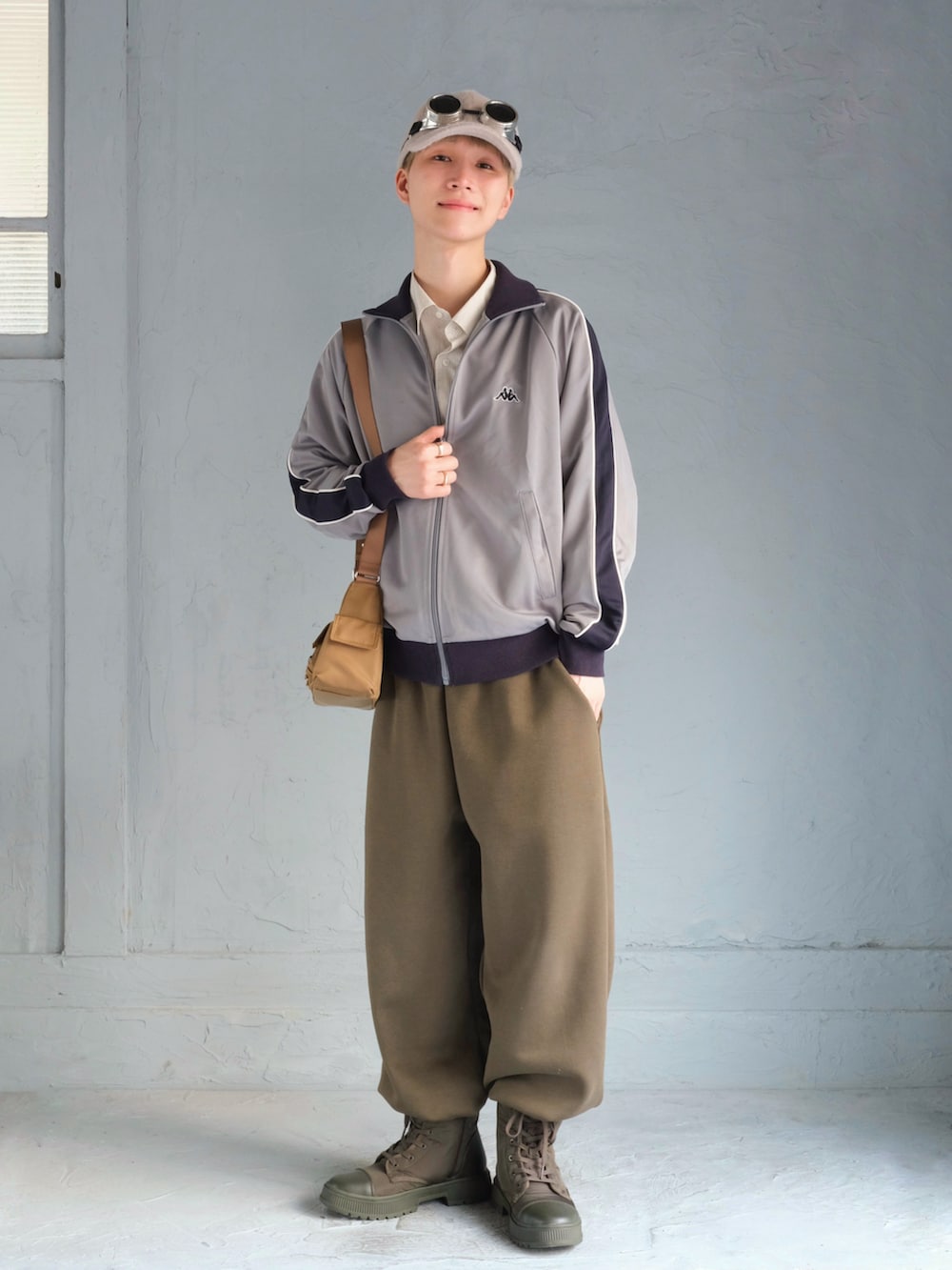 ブルー系のジャージ、ベージュ系のショルダーバッグ、グリーン系のスウェットパンツを着用したメンズの秋コーディネートの2枚目の写真