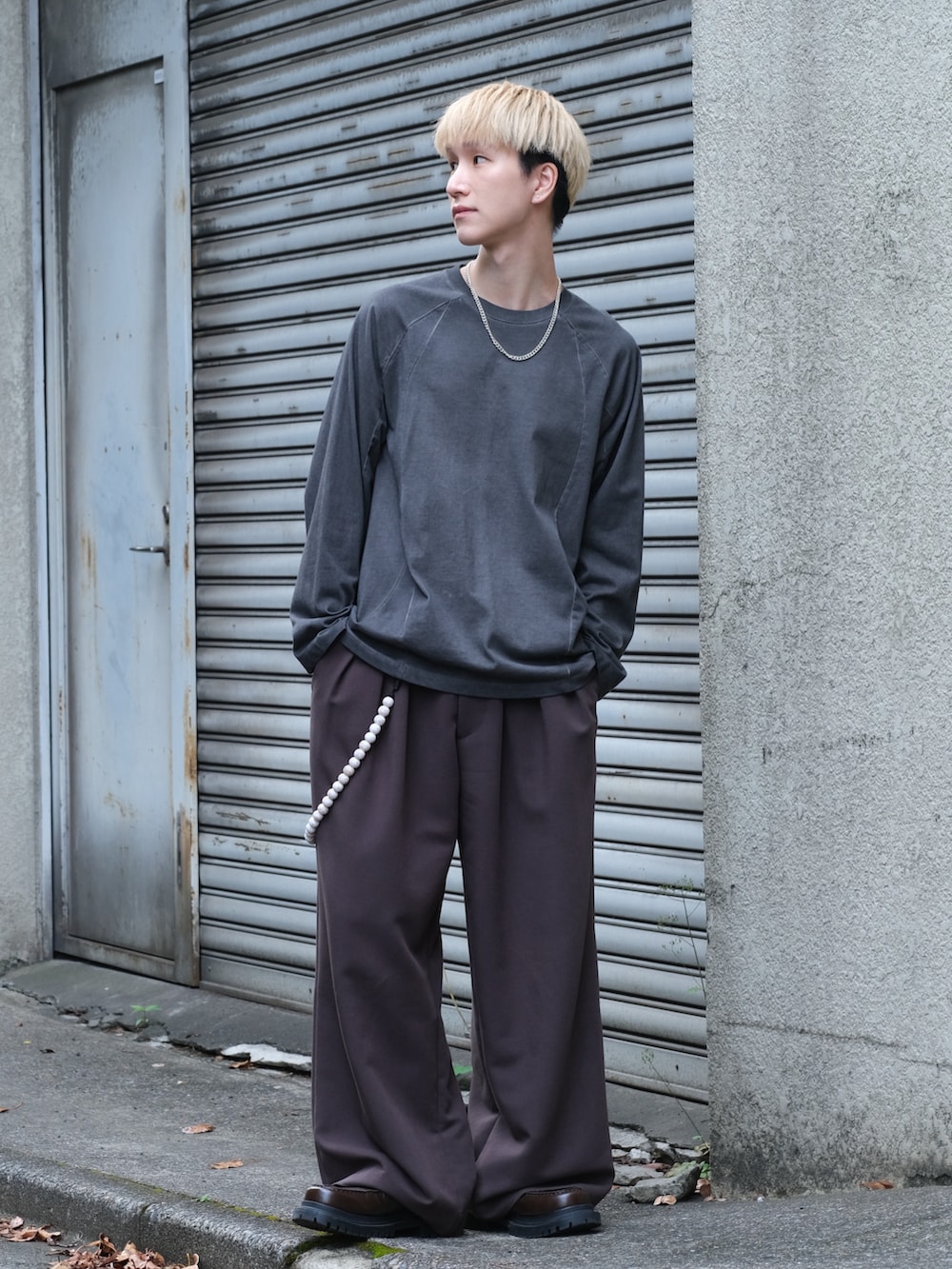 ブラック系のTシャツ/カットソー、ブラウン系のスラックス、ブラウン系のシューズを着用したメンズの夏コーディネートの5枚目の写真