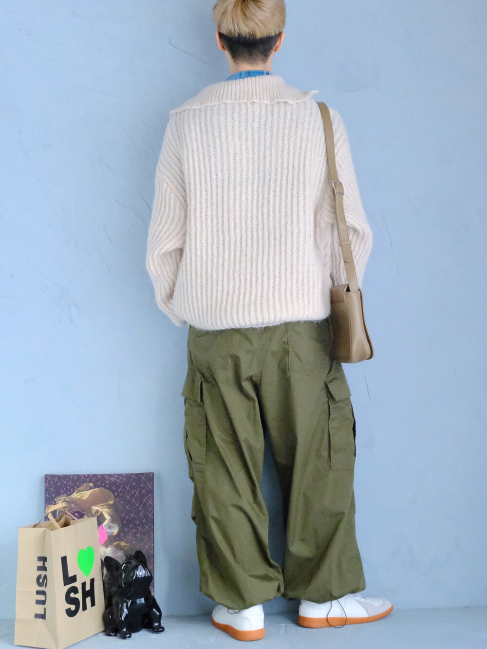 ホワイト系のスニーカー、グリーン系のパンツ、ベージュ系のショルダーバッグを着用したメンズの冬コーディネートの3枚目の写真