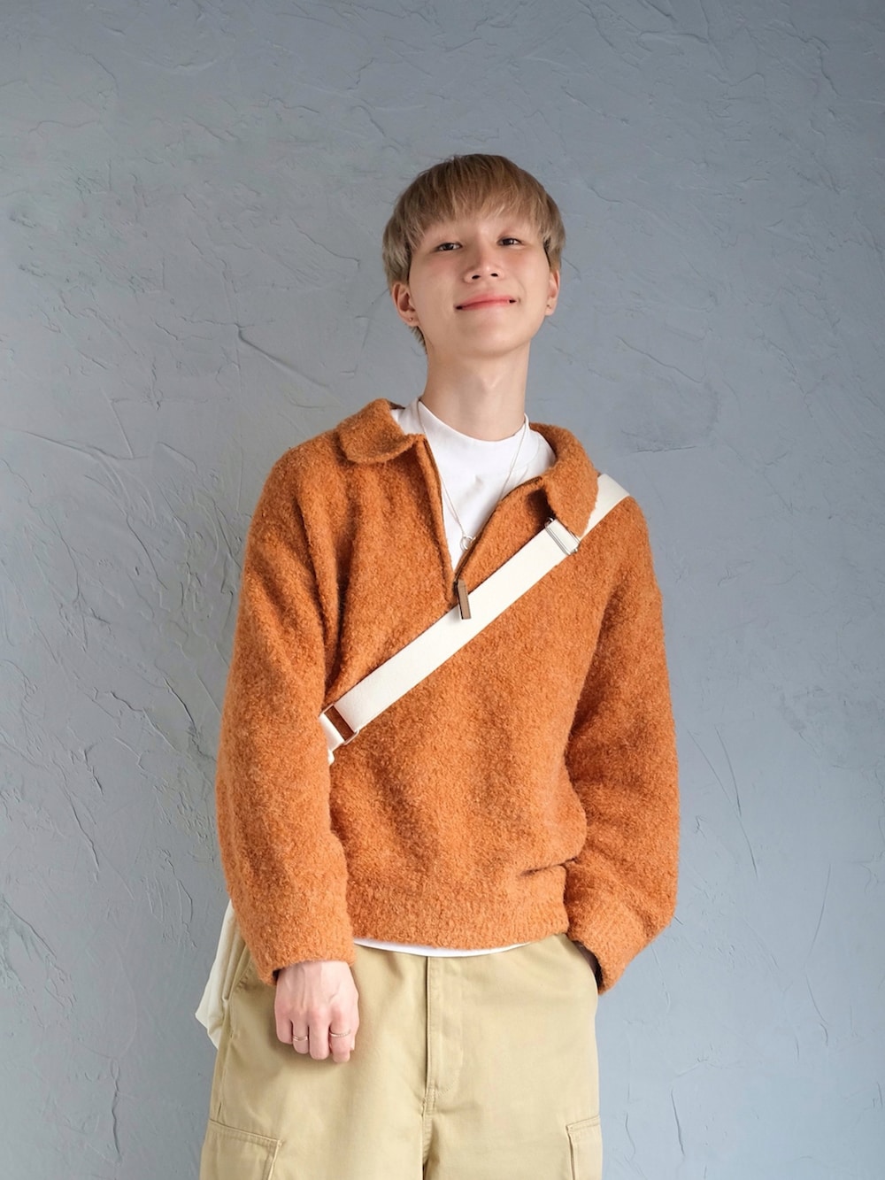 オレンジ系のニット/セーター、ベージュ系のカーゴパンツ、ブラウン系のローファーを着用したメンズの冬コーディネートの2枚目の写真