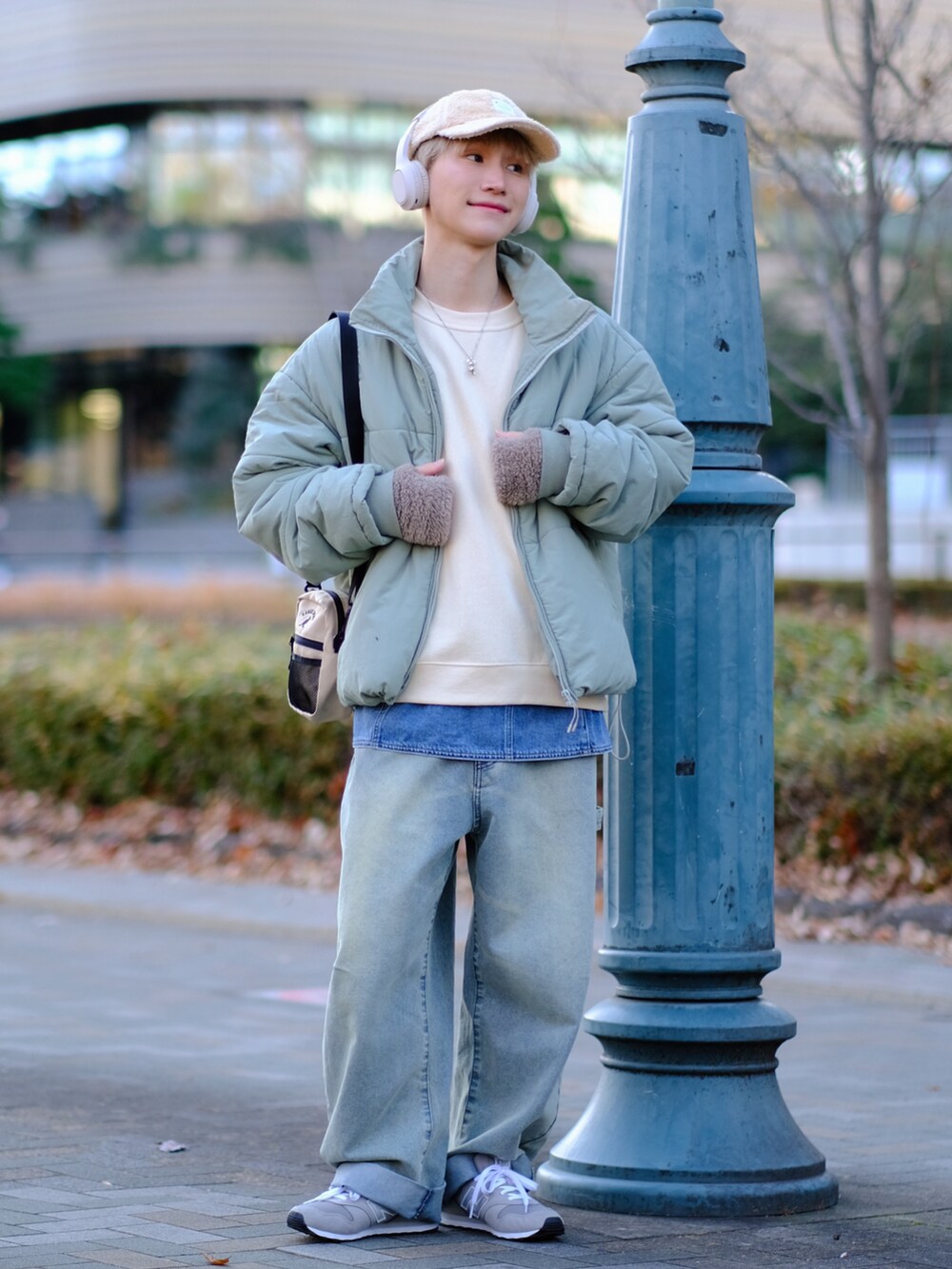 ブルー系のデニムパンツ、グレー系のスニーカー、ベージュ系のスウェットを着用したメンズの冬コーディネートの4枚目の写真