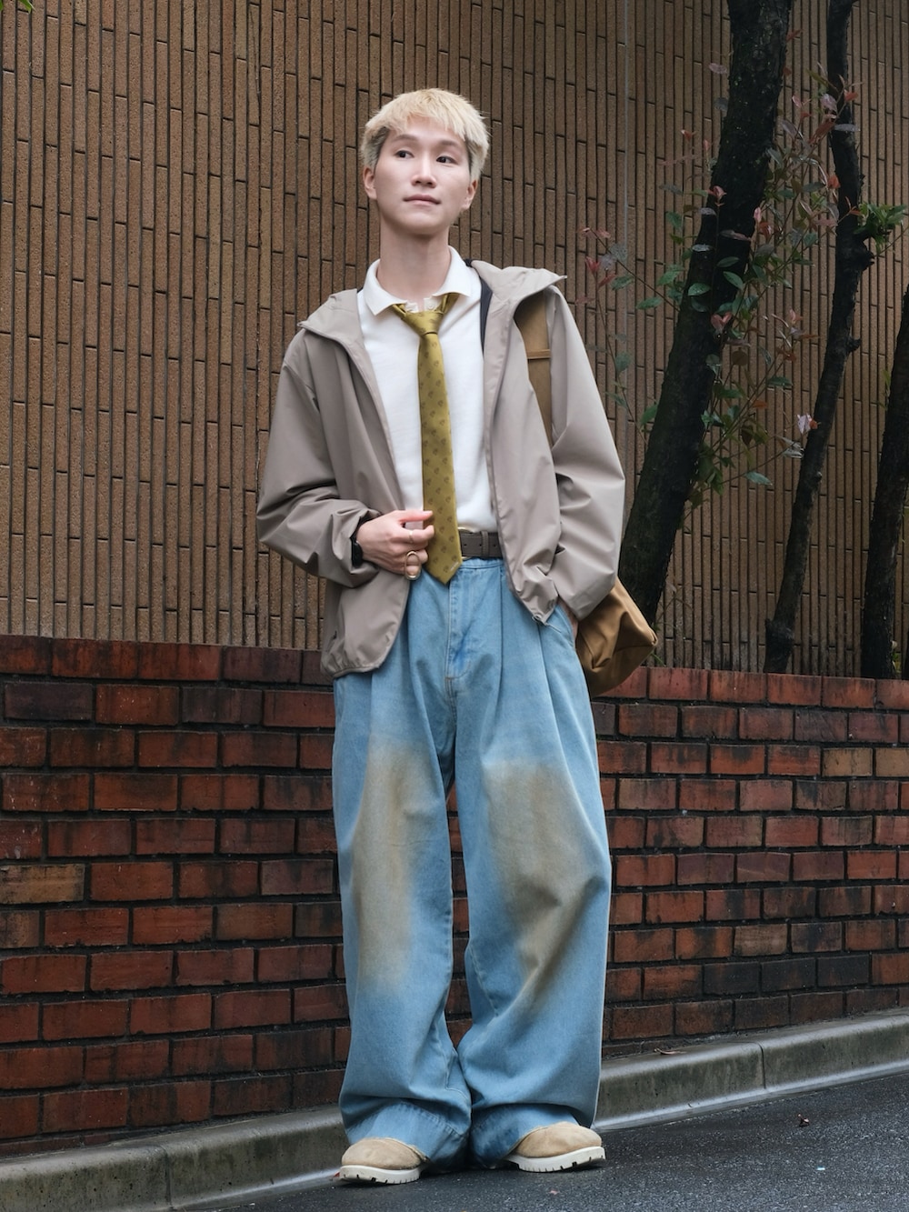 ブルー系のデニムパンツ、イエロー系のネクタイ、ホワイト系のポロシャツを着用したメンズの秋コーディネートの4枚目の写真