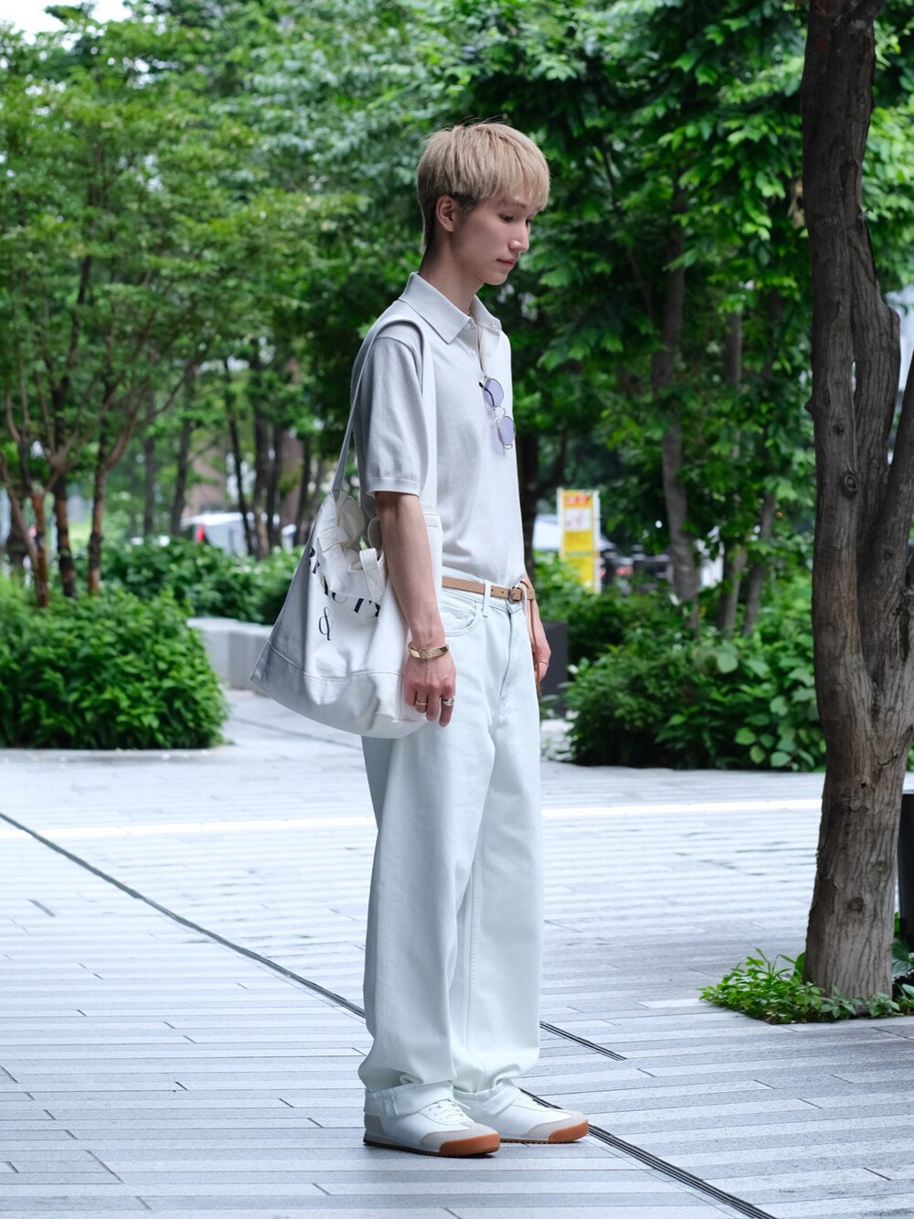 ホワイト系のデニムパンツ、ホワイト系のポロシャツ、ホワイト系のスニーカーを着用したメンズの夏コーディネートの3枚目の写真