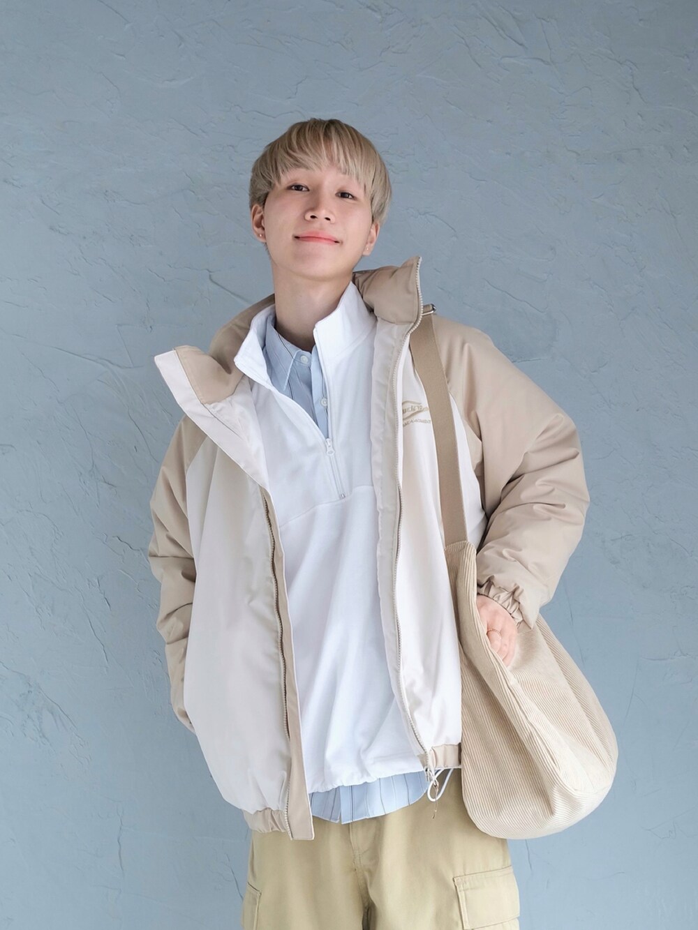 ホワイト系のスニーカー、ベージュ系のダウンジャケット/コート、ホワイト系のTシャツ/カットソーを着用したメンズの冬コーディネートの2枚目の写真