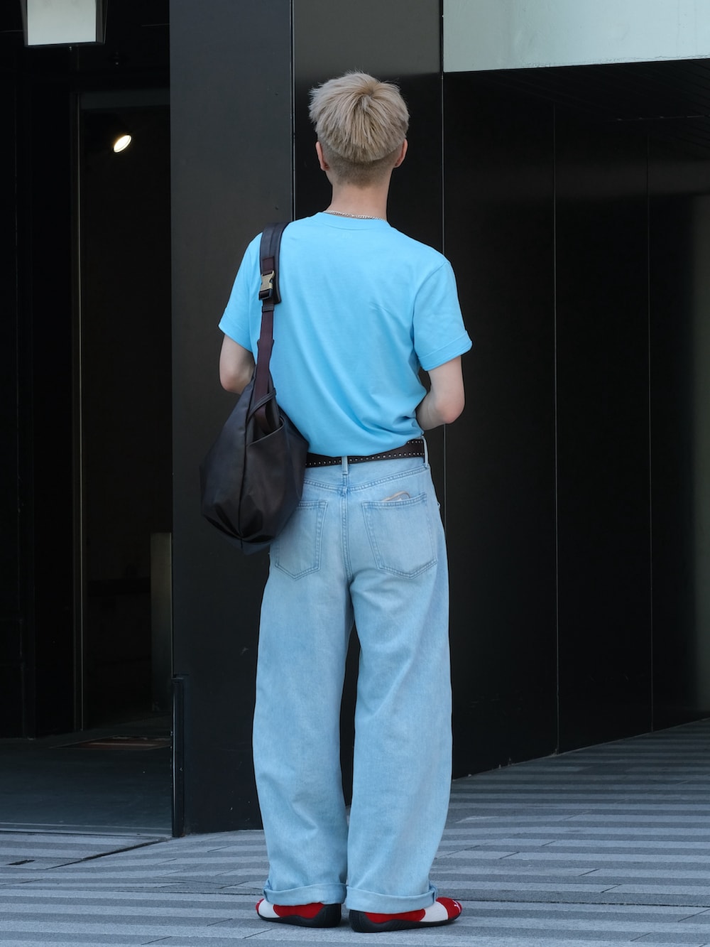 レッド系のスニーカー、ブルー系のTシャツ/カットソー、ブルー系のデニムパンツを着用したメンズの夏コーディネートの4枚目の写真