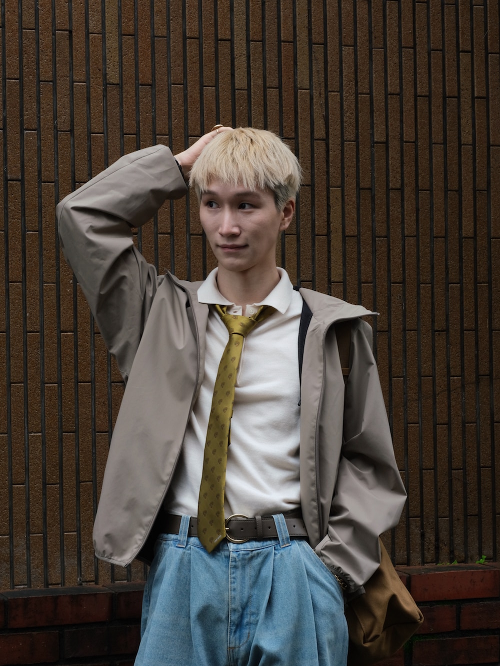 ブルー系のデニムパンツ、イエロー系のネクタイ、ホワイト系のポロシャツを着用したメンズの秋コーディネートの2枚目の写真