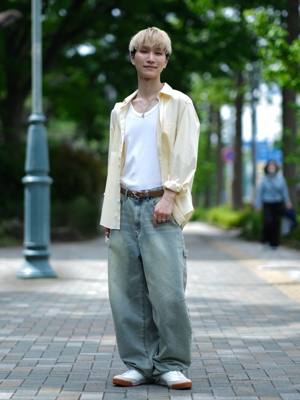 ブルー系のデニムパンツ、ホワイト系のスニーカー、ホワイト系のショルダーバッグを着用したメンズの夏コーディネートの4枚目の写真