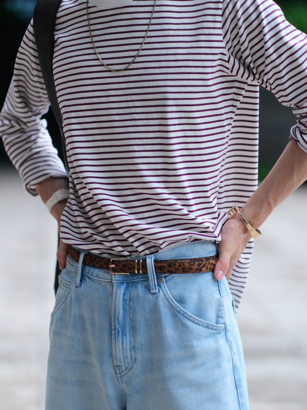 レッド系のTシャツ/カットソー、ブルー系のデニムパンツ、ブラウン系のショルダーバッグを着用したメンズの夏コーディネートの3枚目の写真